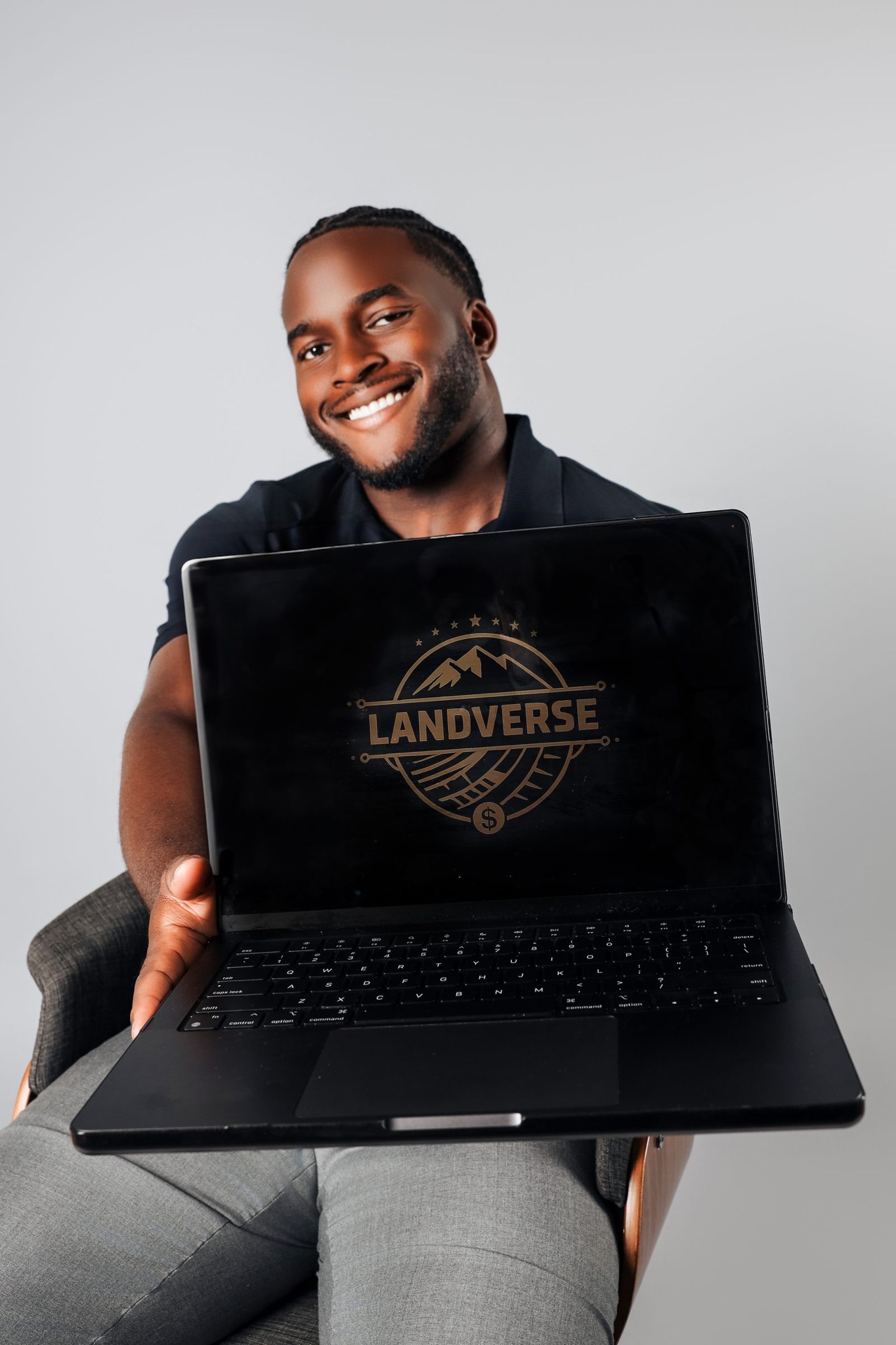 Olufemi Ajose holding a laptop displaying LandVerse